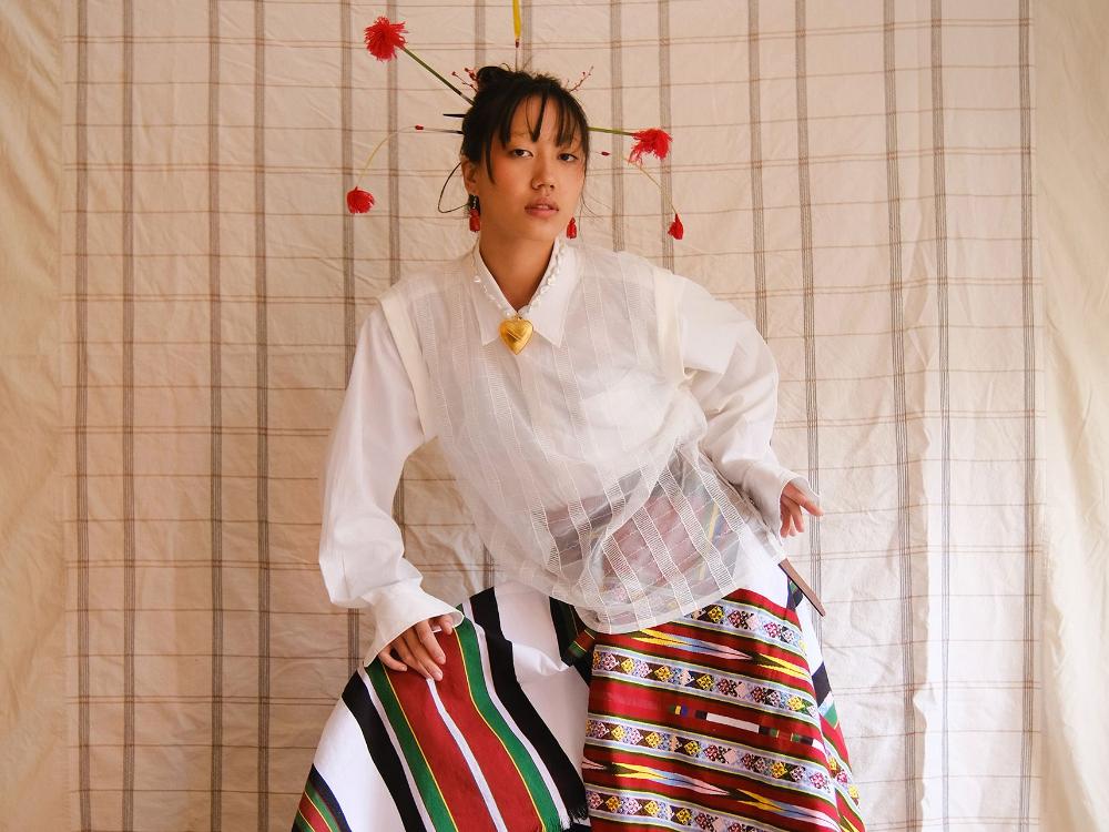 Maria Guite wears a puanchei styled with a sheer top from Shia Rai and a necklace from Hannan Jewelry