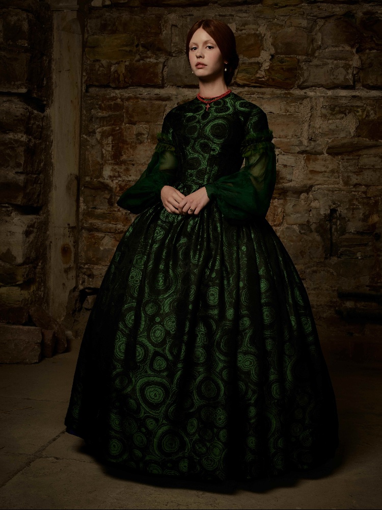 Elizabeth wears her custom rosary and a beetle-green gown