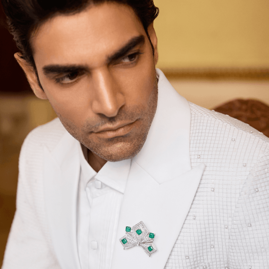 A model in a white suit and brooch by Manish Malhotra High Jewellery