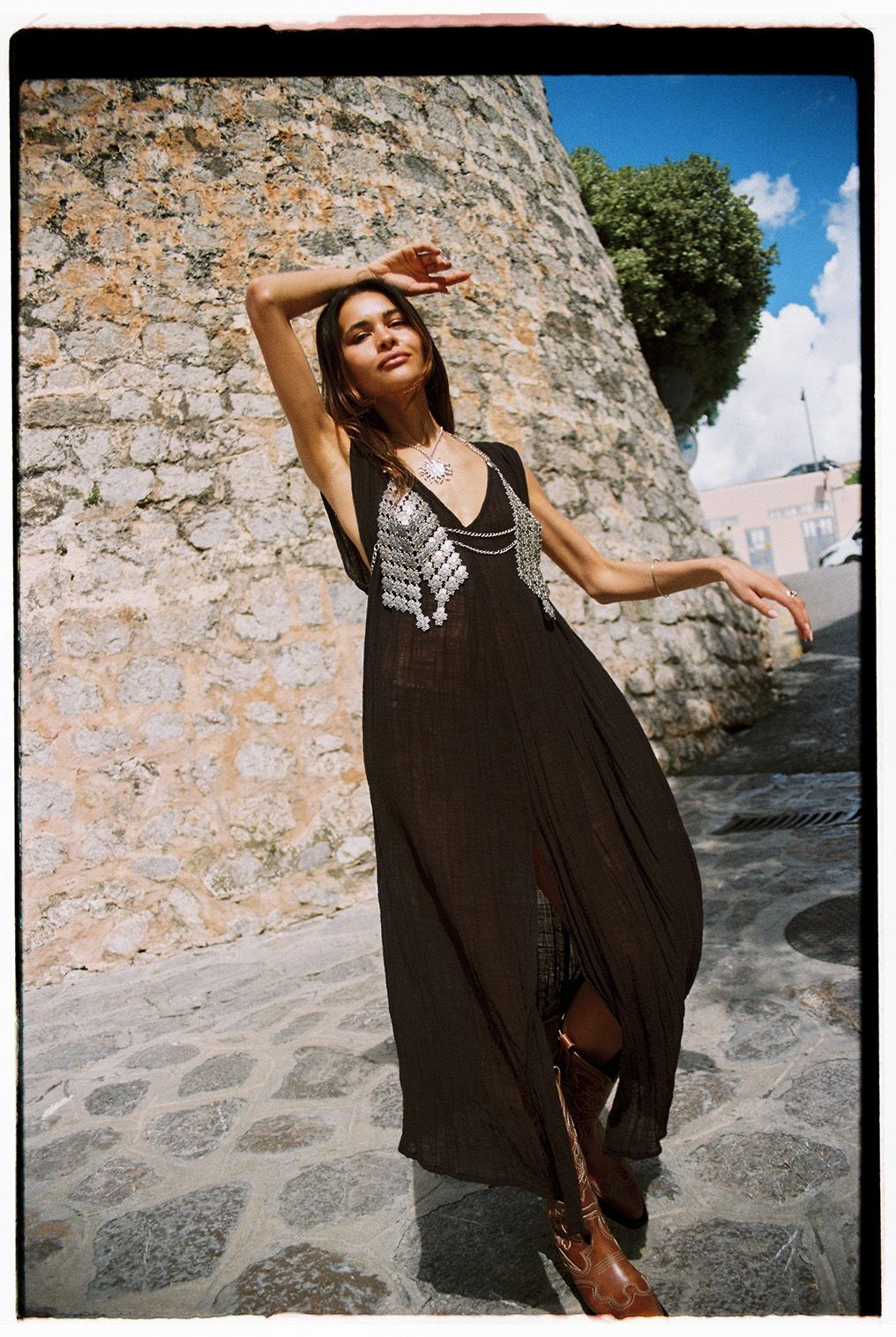 Artist Karimah Hassan wearing a long black dress and stainless steel chainmail bralette top from Studio Tia