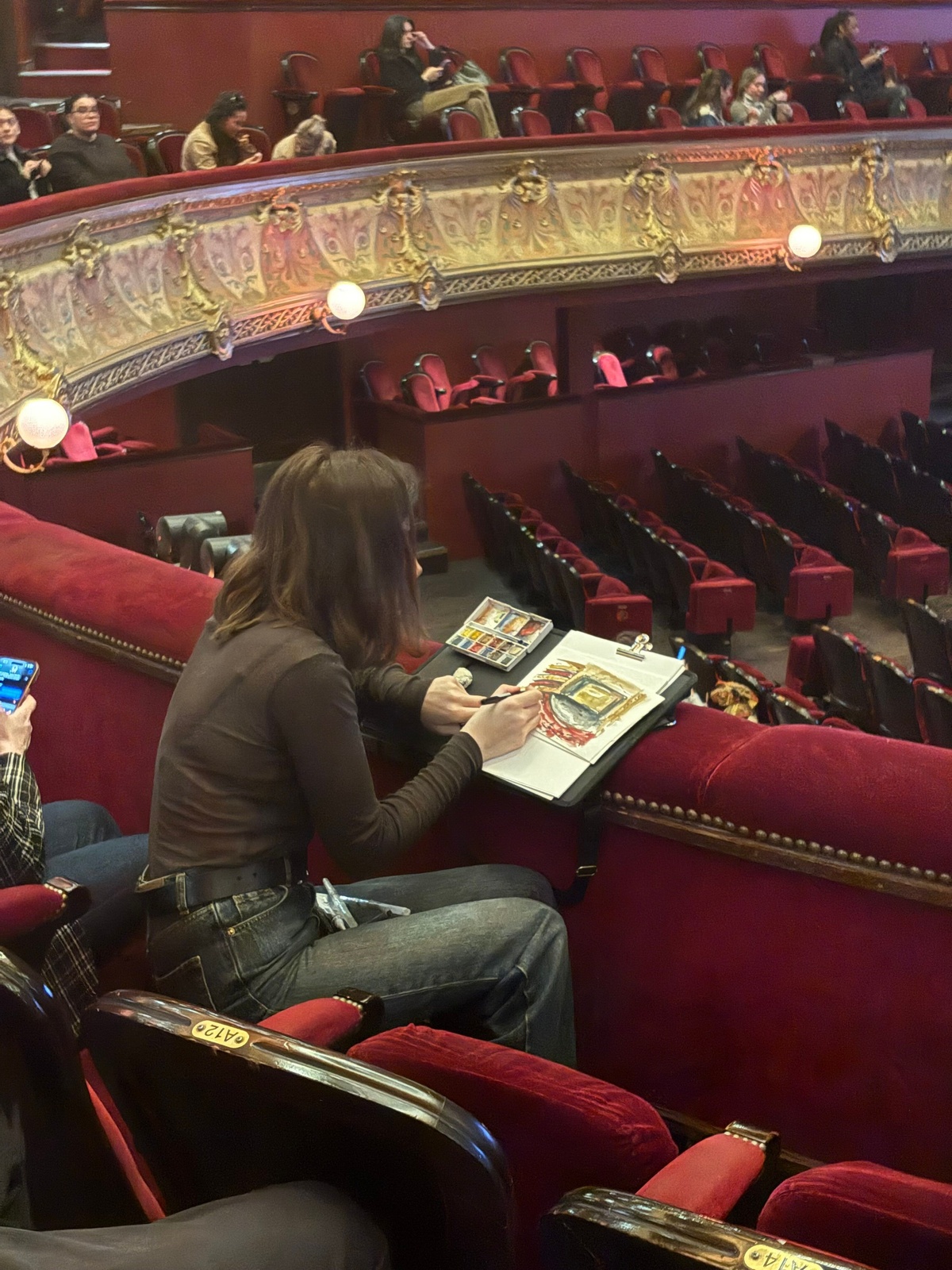 An illustrator sketching and painting at Lyas’s La Watch Party