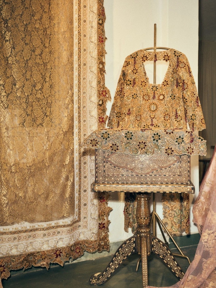 A gold embroidered garment and vintage furniture at Pankaj Heritage's Delhi studio