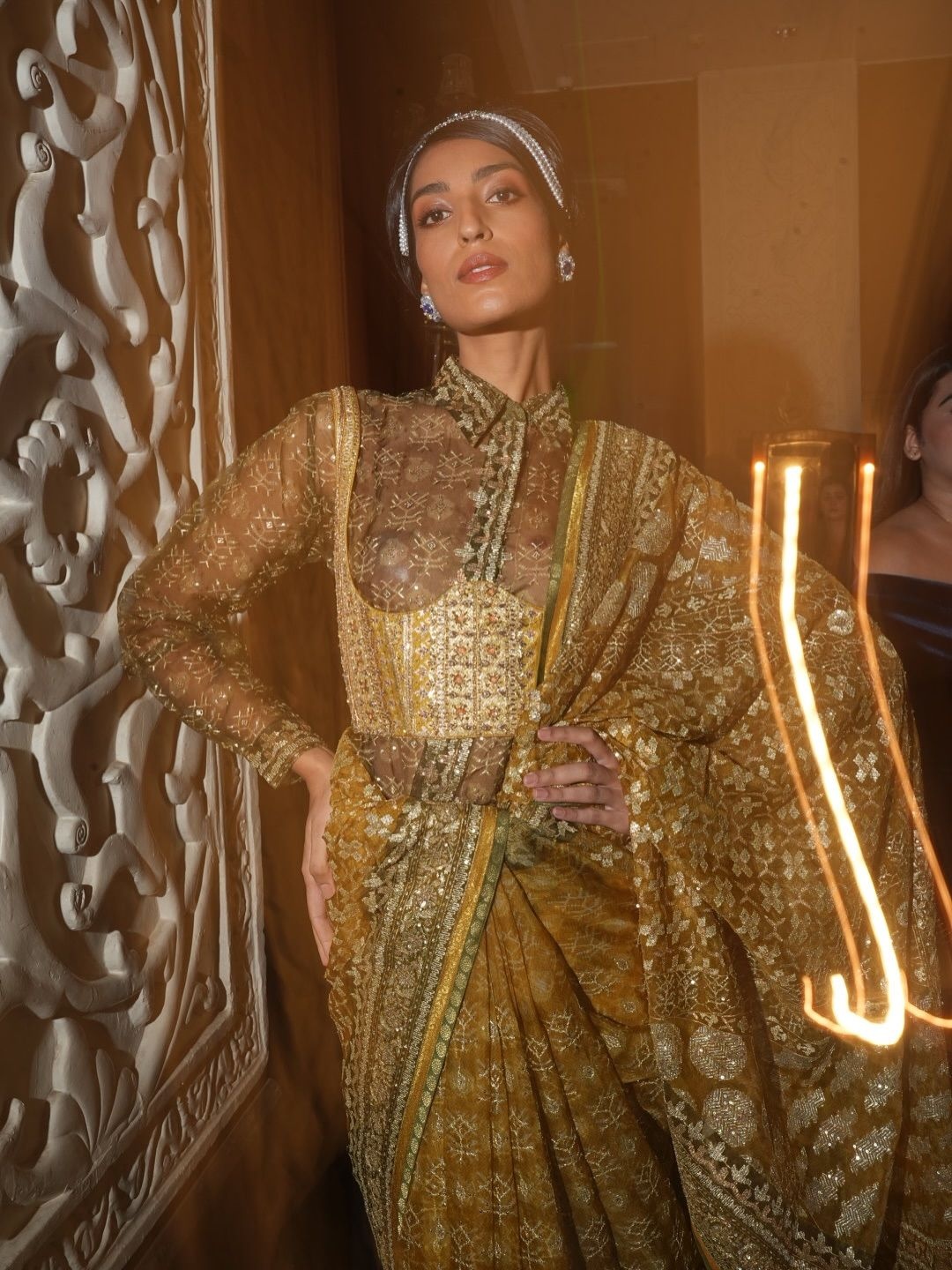 A look from Ritu Kumar's India Couture Week 2025 show featuring a sari worn with a sheer shirt and underbust corset