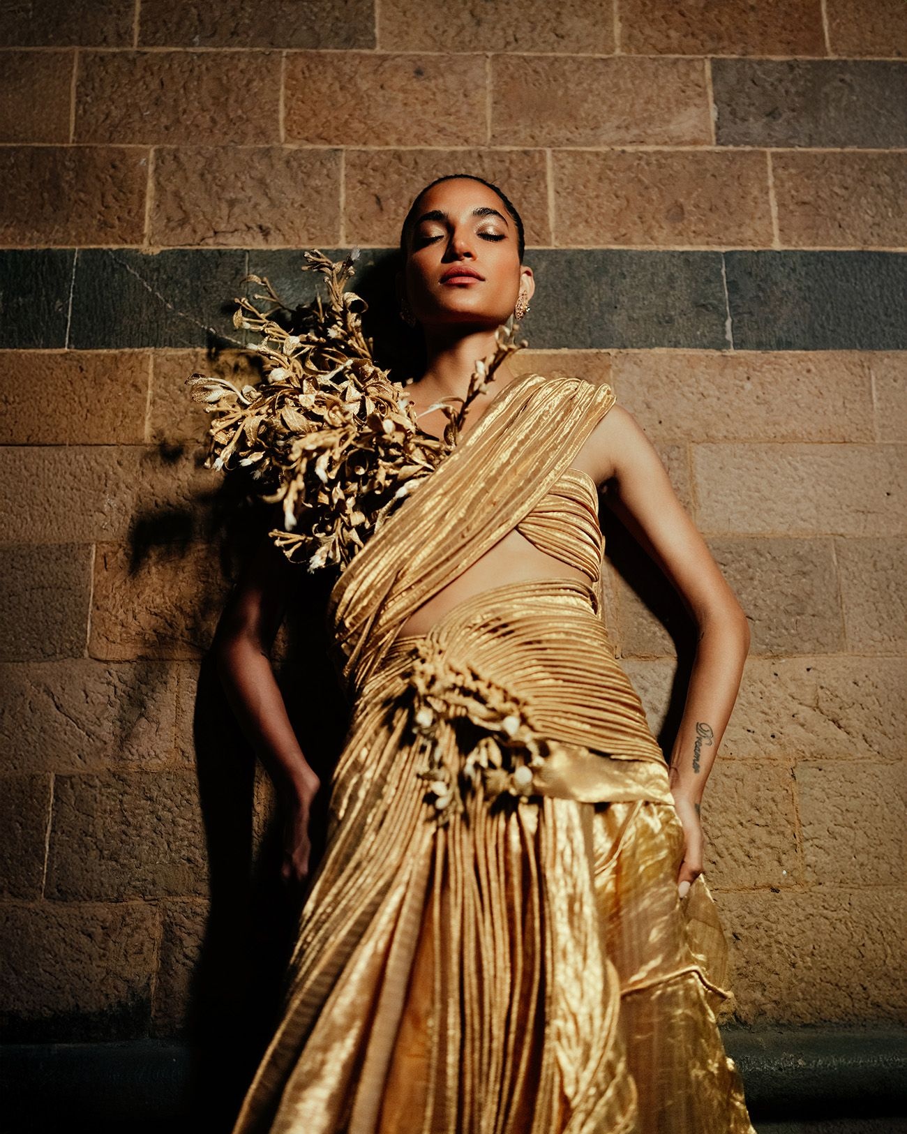 A model wearing a Vaishali S bralette with handcrafted coral cords and silk sari