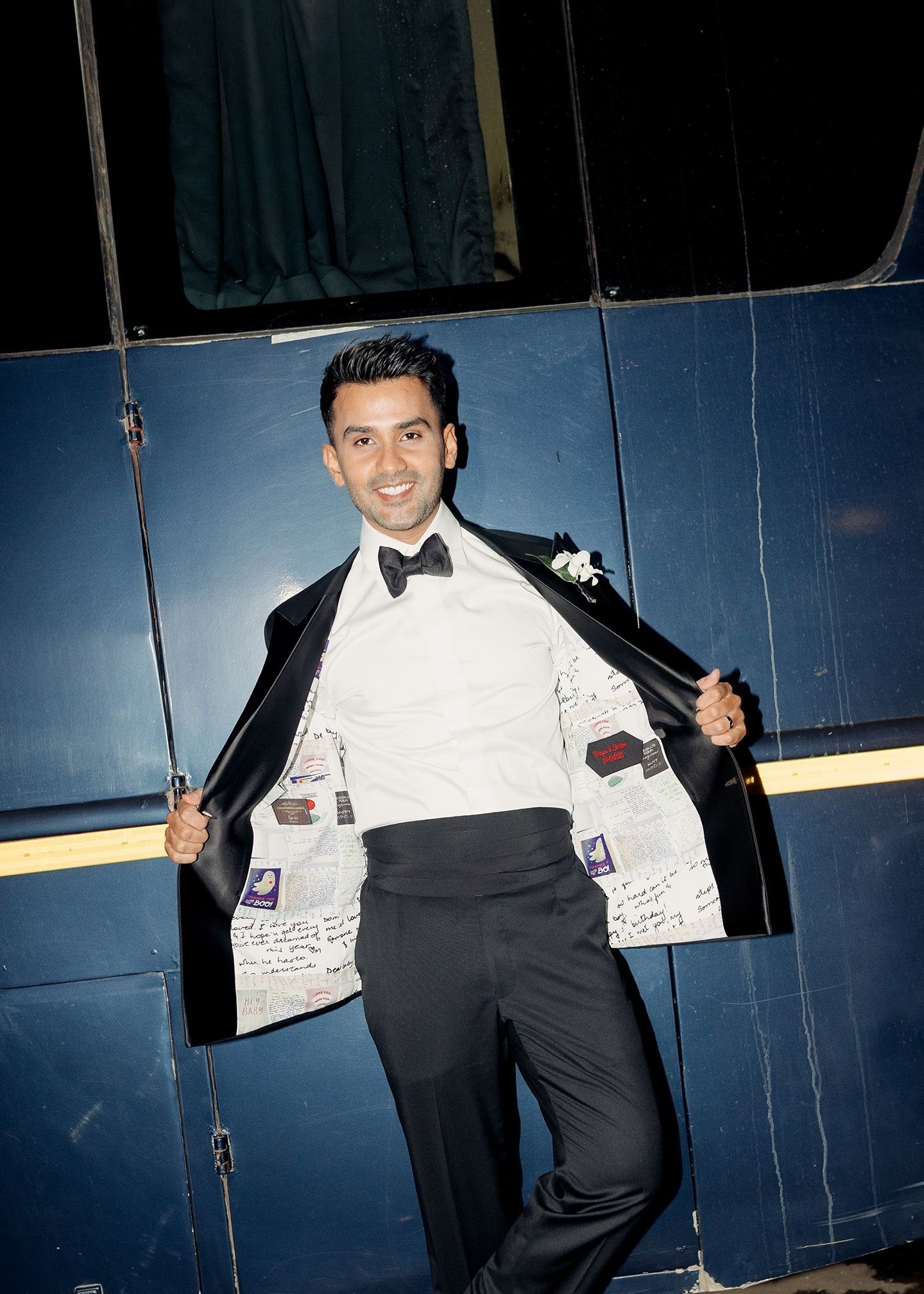 Sheldon Santos at his reception wearing a tuxedo jacket with letters and cards from Meagan Concessio printed on them