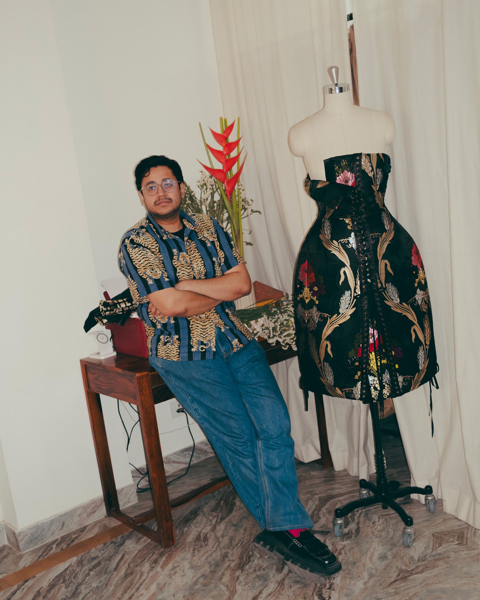 Yash Patil of That Antiquepiece in his studio, posing with a corset dress