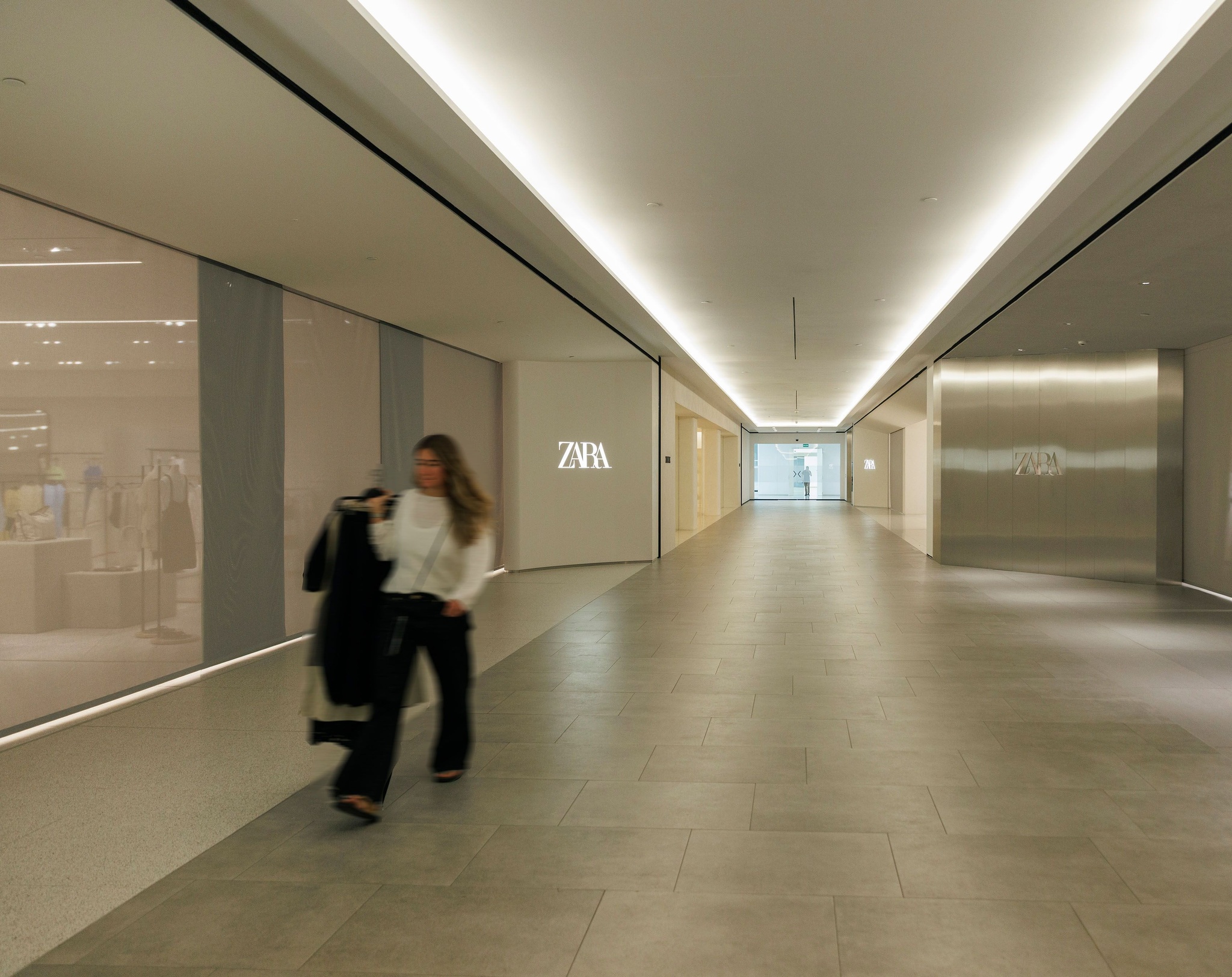 A woman carrying garments outside a Zara pilot store