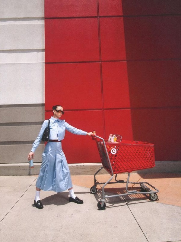 Emma Chamberlain holding a red Target shopping cart