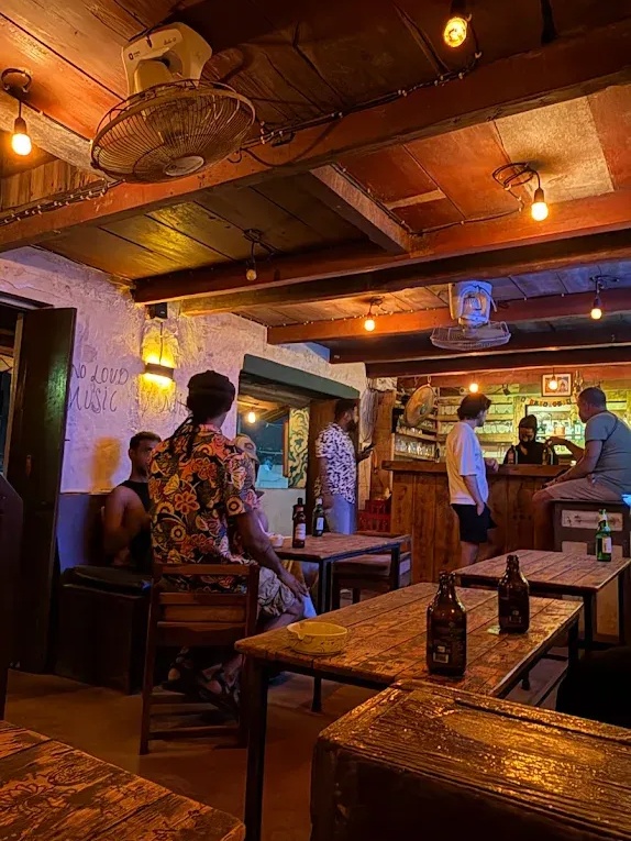 Bar with dim lights, crowded seating, and walls covered with scribbles