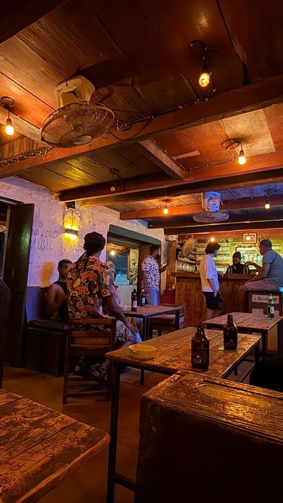 Bar with dim lights, crowded seating, and walls covered with scribbles