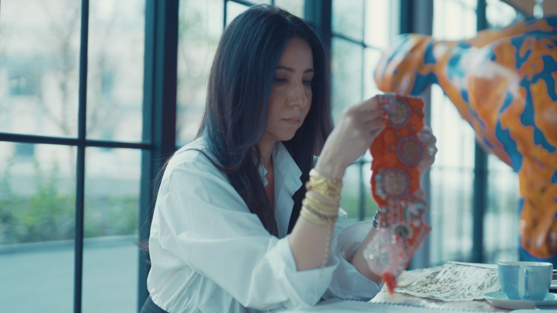 Designer Anamika Khanna holding up embroidered fabric