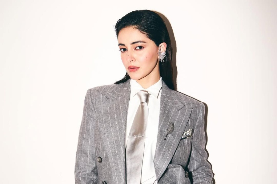 Ananya Panday in a grey pinstripe Ralph Lauren suit with a silver tie, brooch, and other silver accessories
