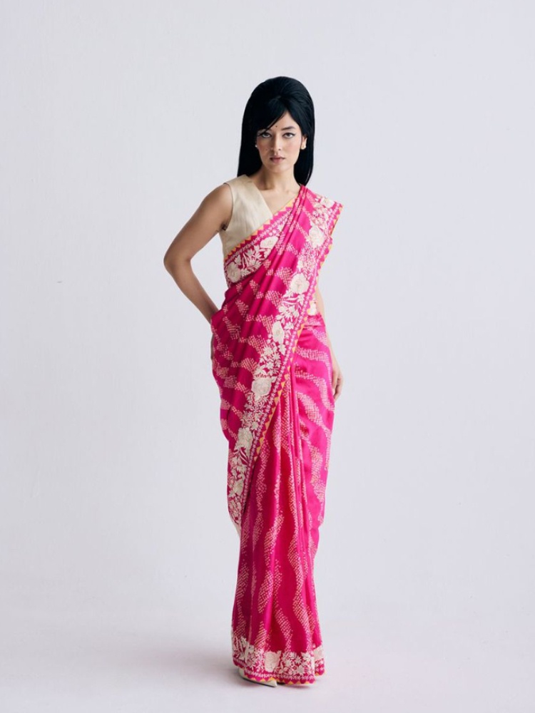 A pink Ashdeen sari with delicate bandhani dots arranged in leheriya-style geometric lines and a parsi gara border