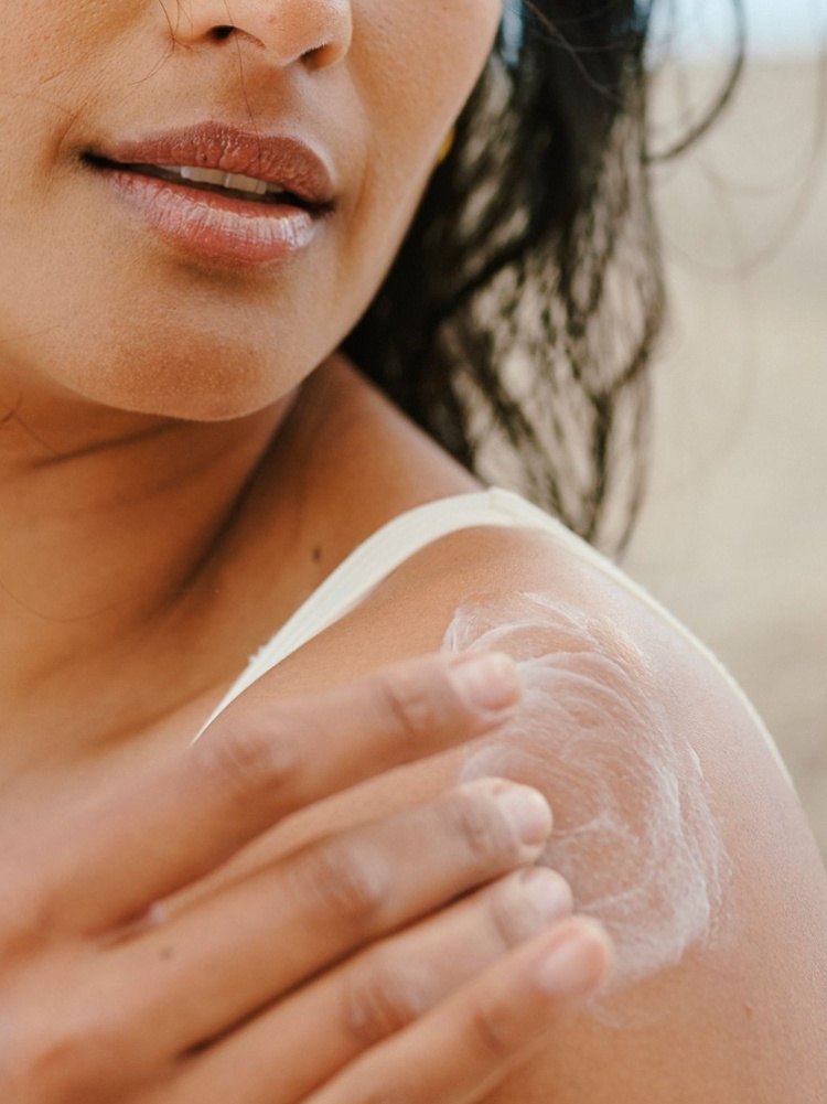 A woman applying sunscreen