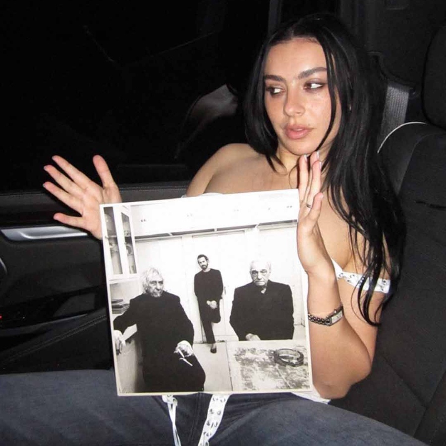Charli XCX holding her new album, 'Music, Fashion, Film'