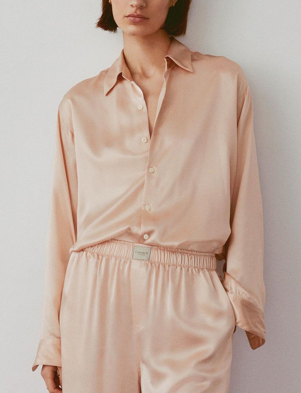 A model wearing a silk pyjama set by minimalist affordable luxury brand Comme Si