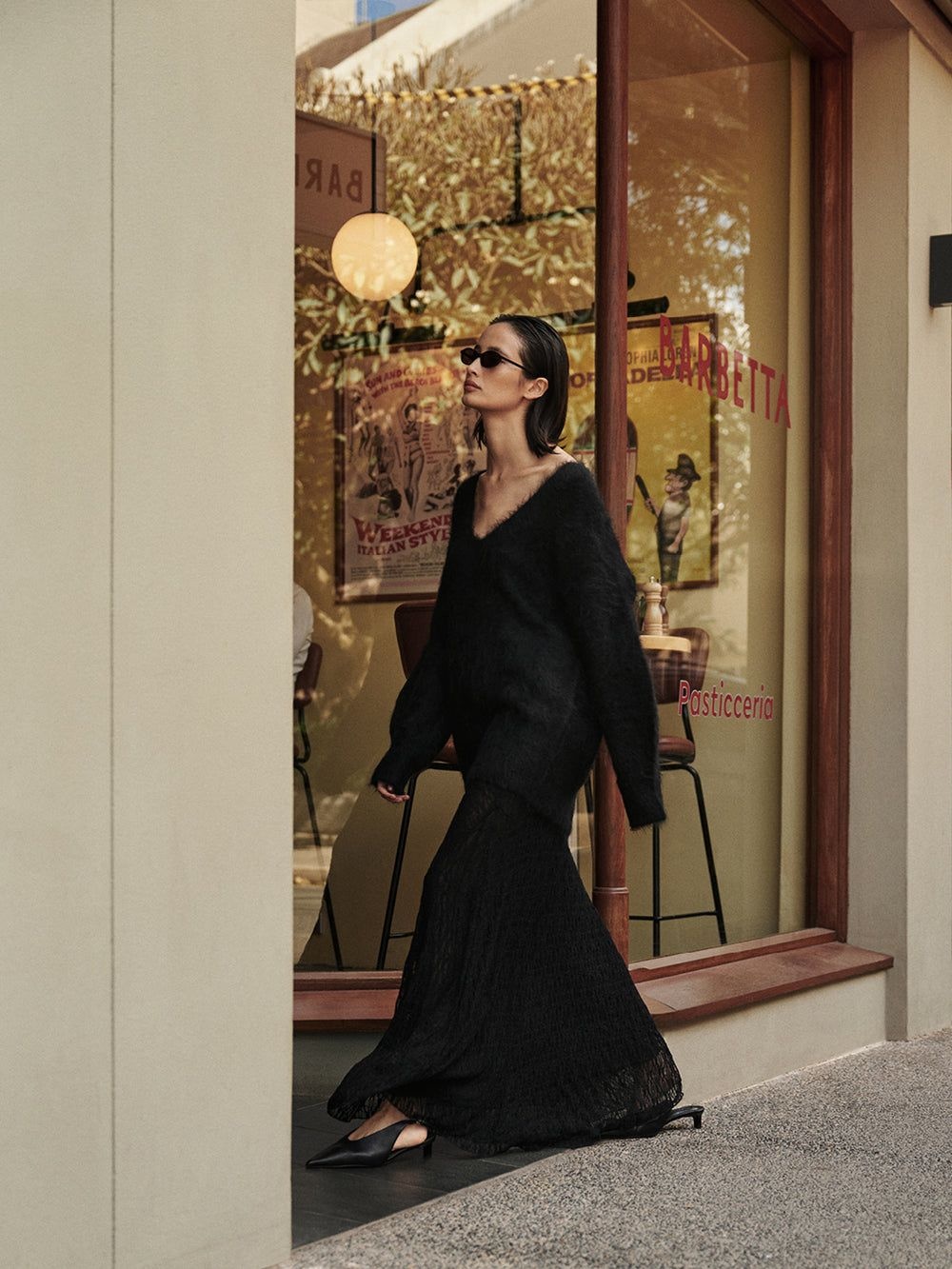 A Dissh campaign image featuring a model in a black skirt and knit | The Nod minimalist affordable luxury brands