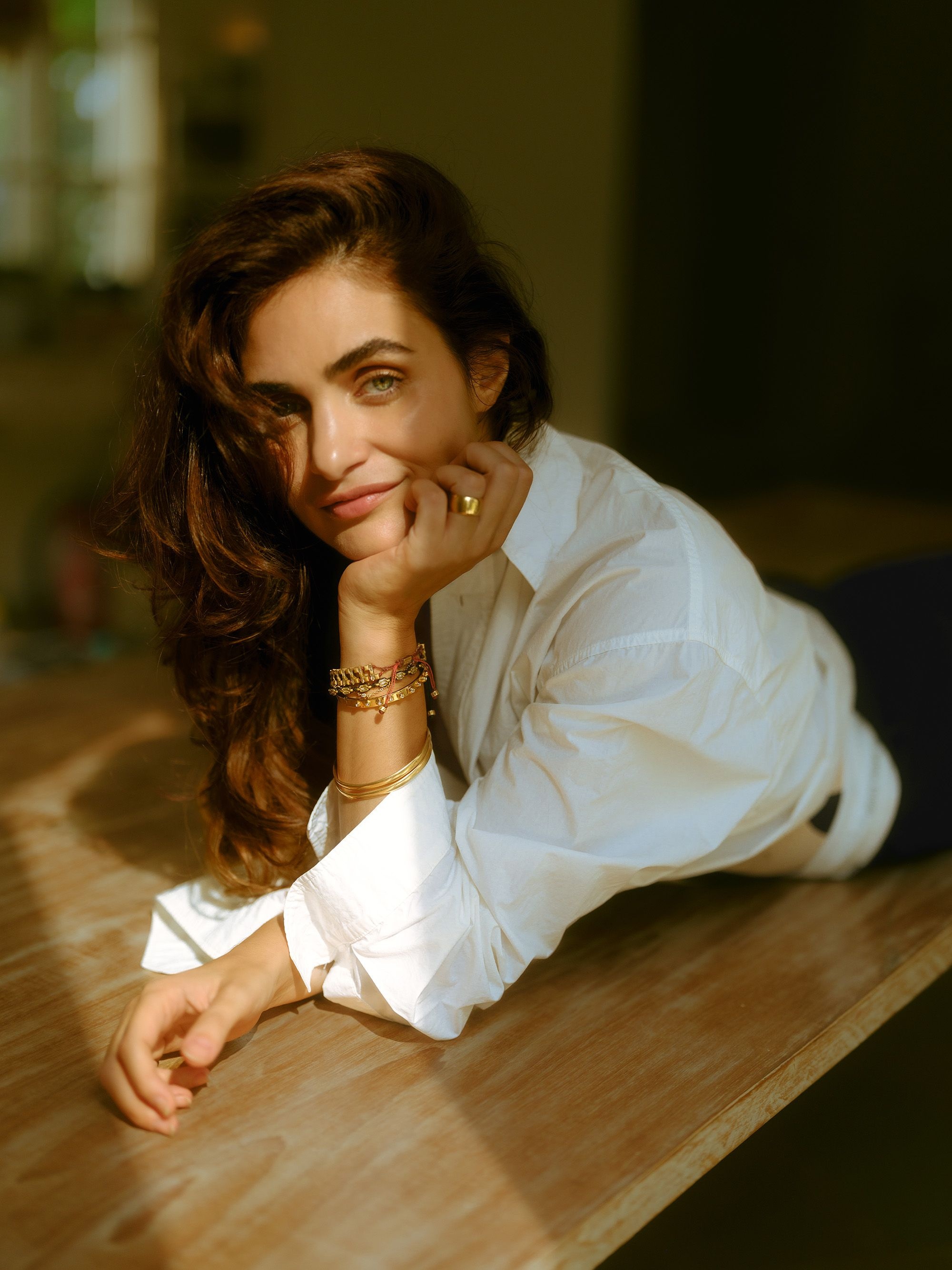 Gabriella in a Nanushka shirt, Toteme swimsuit, and The Frankie Shop trousers