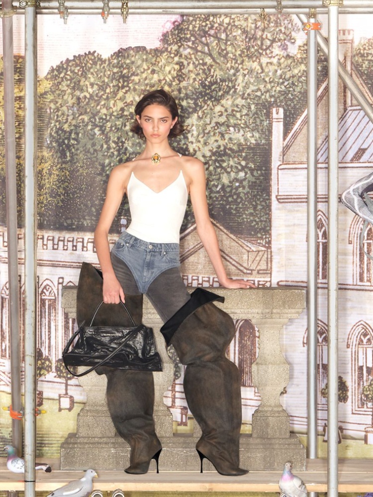 A model wearing the invisible strap tank top and thigh high boots from the H&M Glenn Martens Collection