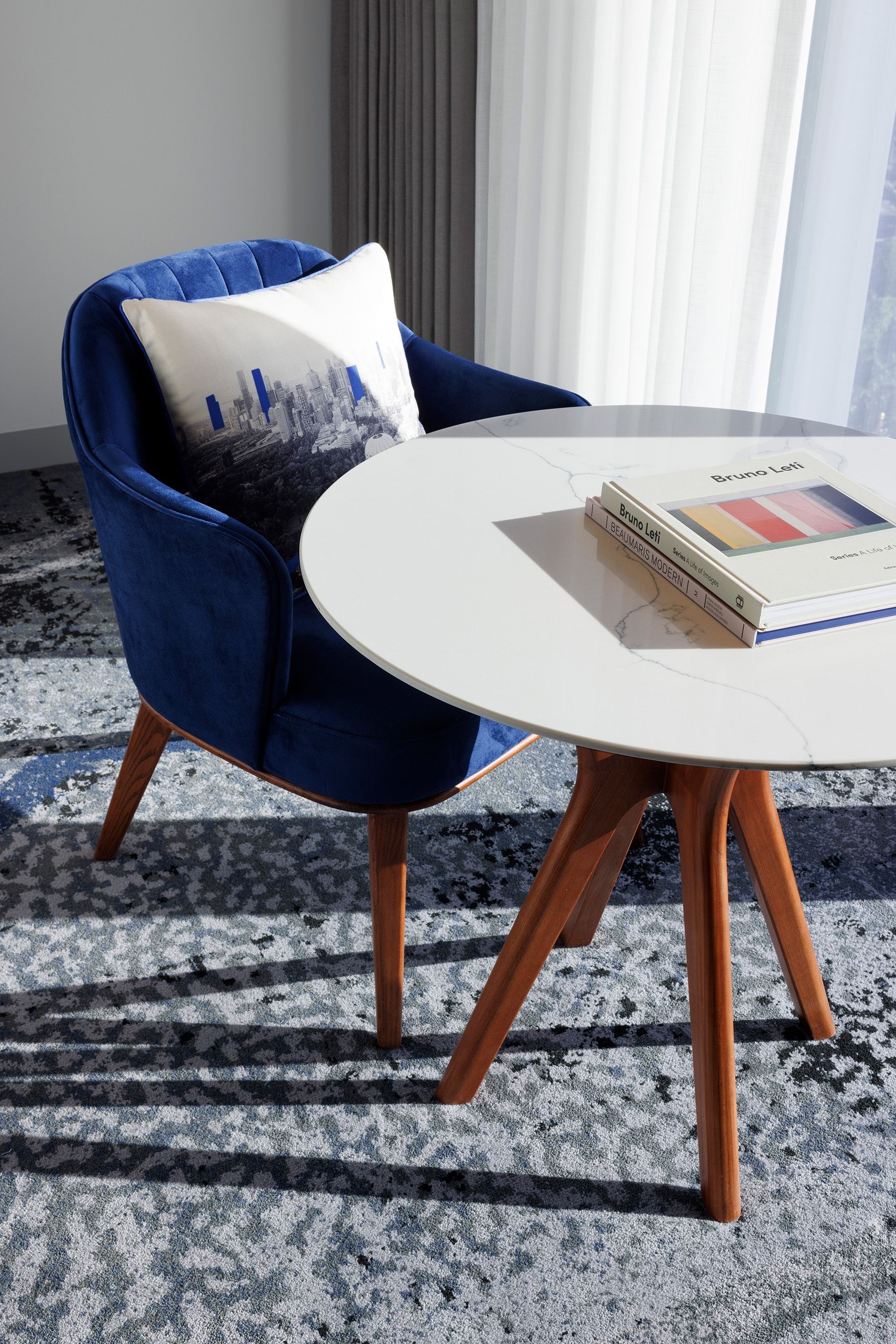 An air-force blue velvet chair and coffee table in the rooms