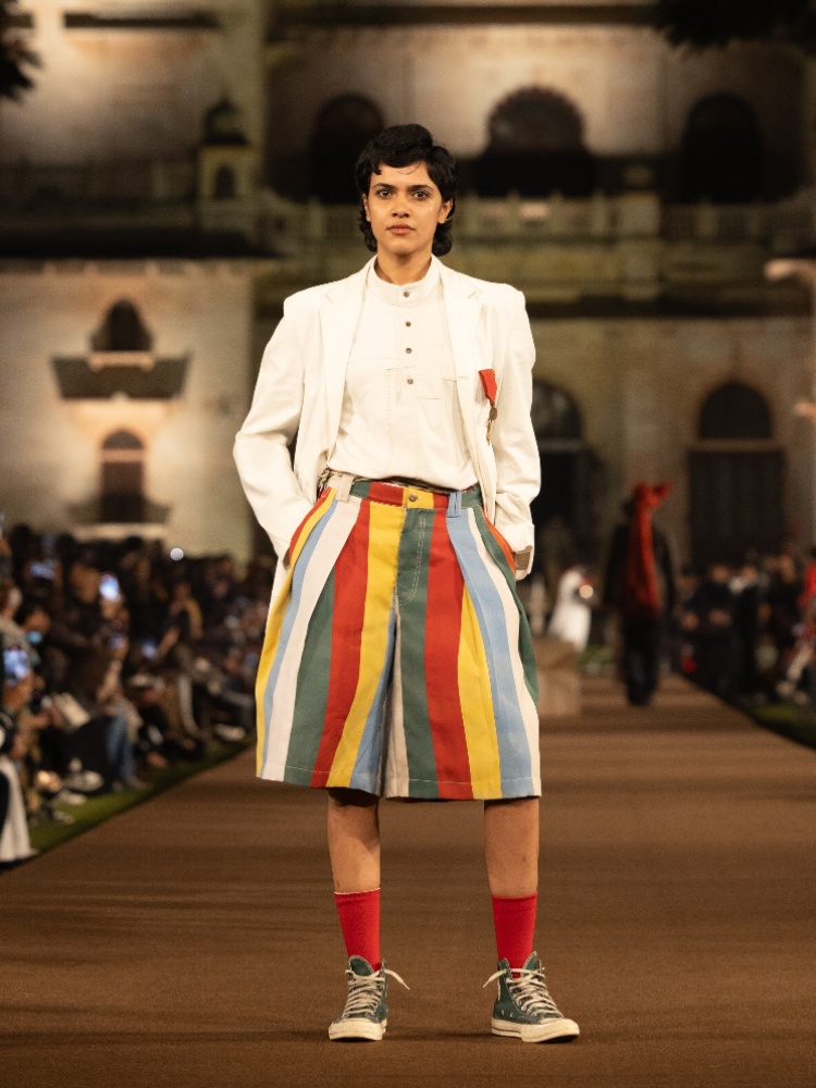 A model on the Rkive City X Mayo College runway wearing a white blazer, Pachranga shorts, red socks and Converse