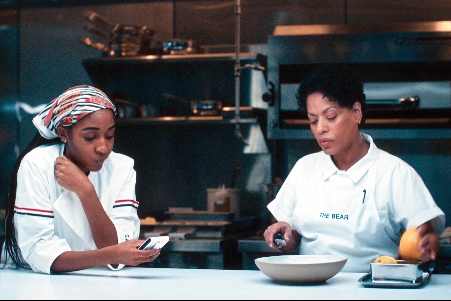Ayo Edebiri as Chef Sydney in The Bear wearing custom Thom Browne chef's whites and a scarf