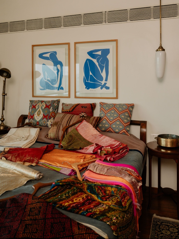 A bed strewn with saris