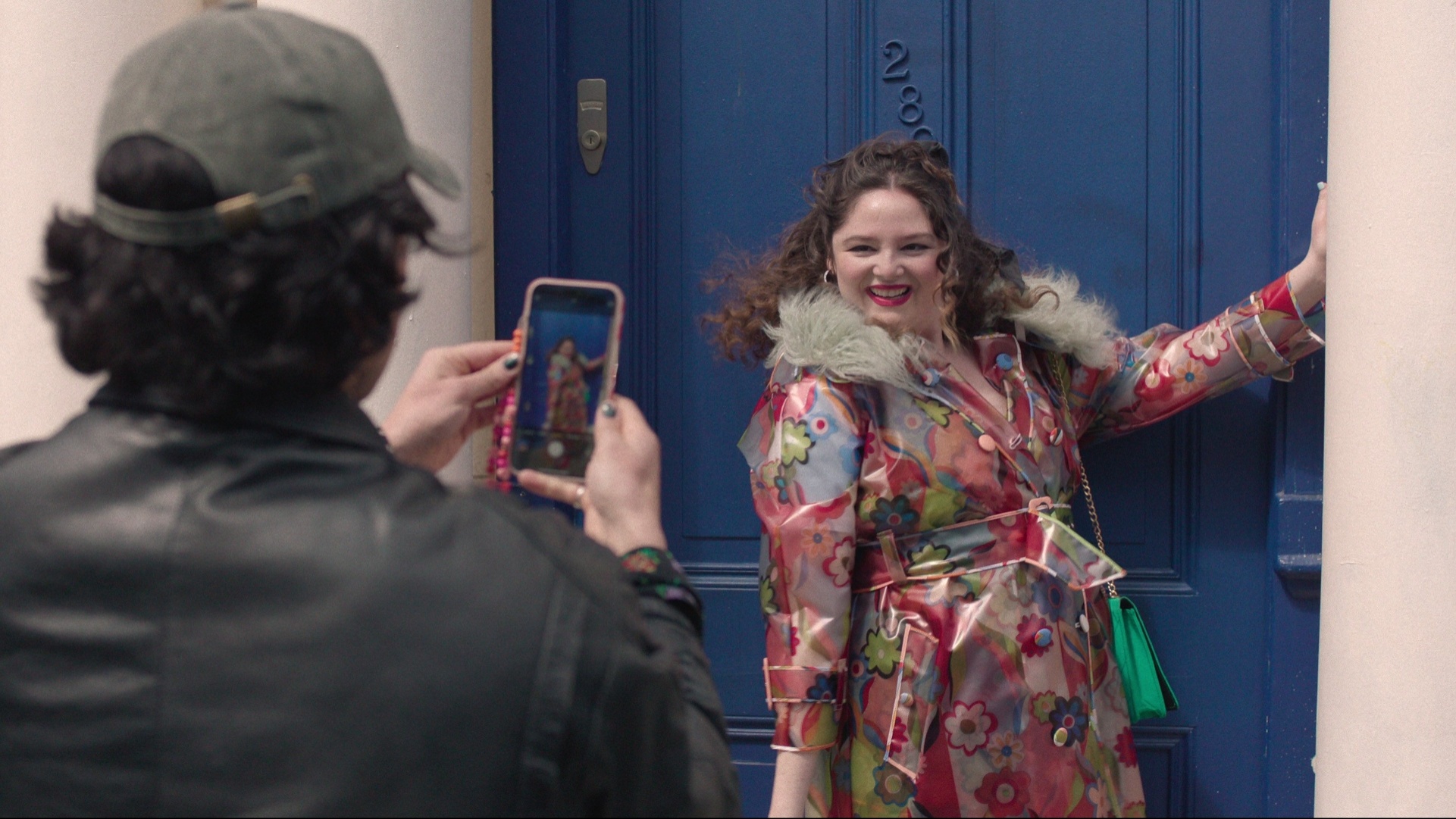 Megan Stalter as Jessica in a floral, fur-collared trench coat by Celia B